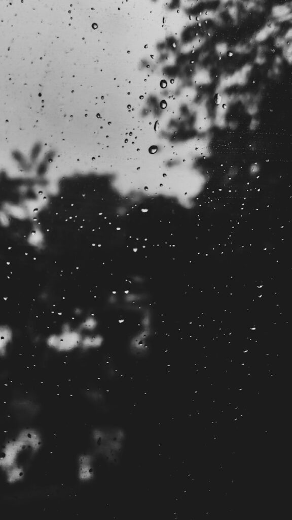 a black and white photo of rain drops on a window