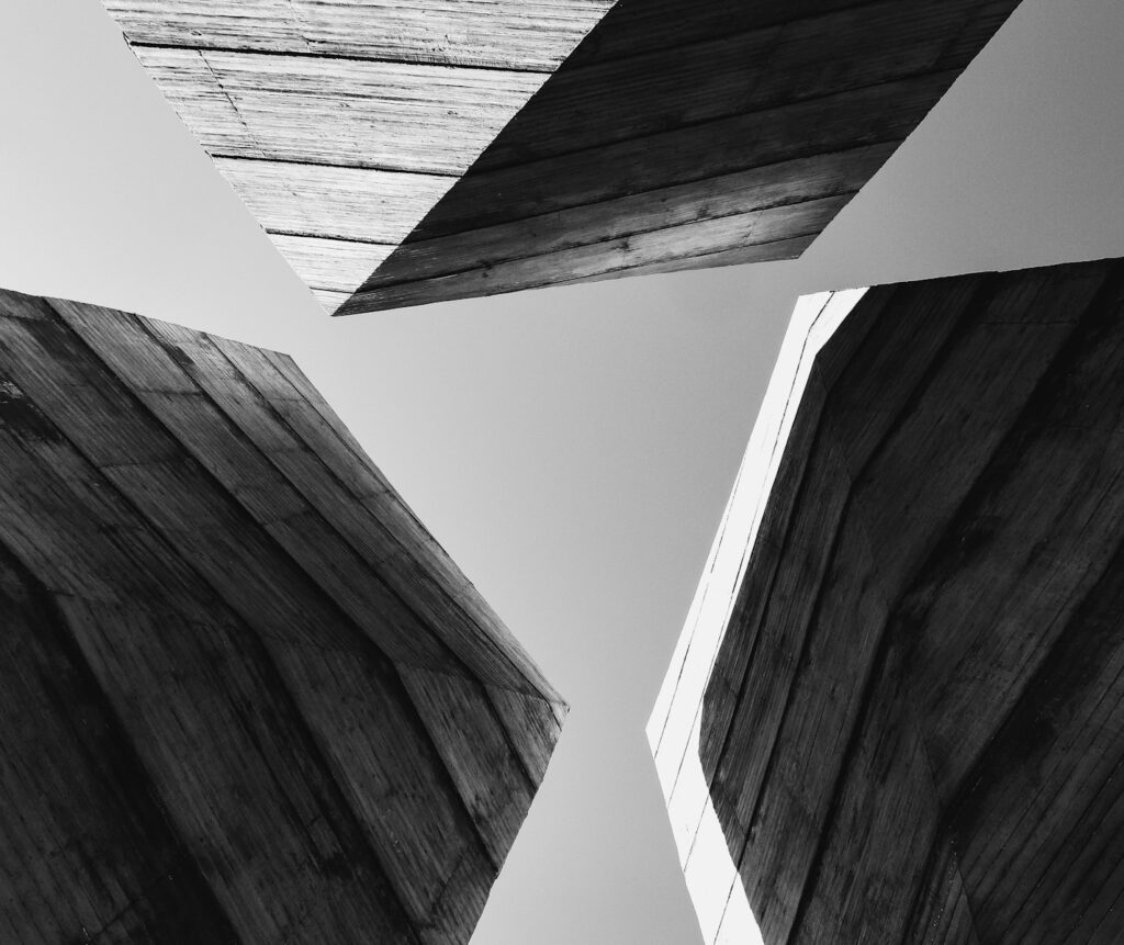 a black and white photo of three wooden structures